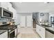 Modern kitchen with granite countertops, stainless steel appliances, and an open layout to the house at 8887 Little Bluestem Dr, Land O Lakes, FL 34637