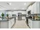 Bright, modern kitchen features white cabinets, stainless steel appliances, and granite countertops at 8887 Little Bluestem Dr, Land O Lakes, FL 34637