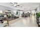 Spacious living room open to the kitchen featuring a comfortable sectional sofa and modern ceiling fan at 8887 Little Bluestem Dr, Land O Lakes, FL 34637