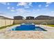 Backyard view of pool and hot tub with stone tile surround and view of neighboring homes at 8887 Little Bluestem Dr, Land O Lakes, FL 34637
