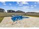 Backyard view of pool and hot tub with stone tile surround and view of neighboring homes at 8887 Little Bluestem Dr, Land O Lakes, FL 34637
