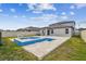Backyard view of pool and hot tub with stone tile surround and view of backyard at 8887 Little Bluestem Dr, Land O Lakes, FL 34637