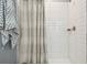 Close up of a shower with tile walls and a striped shower curtain at 8887 Little Bluestem Dr, Land O Lakes, FL 34637