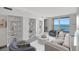 Bright living room with built in shelves, comfortable seating, and balcony access with stunning ocean view at 9 Haig Pl # 310, Dunedin, FL 34698
