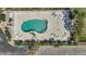 Aerial view of the pool area featuring lounge chairs and shade, set within a white fenced area at 9 Haig Pl # 310, Dunedin, FL 34698
