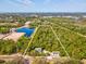 Expansive aerial view of the property, showcasing a large wooded lot, pond, and existing home site at 920 E Lake Dr, Tarpon Springs, FL 34688