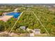 Overhead view of the lot with a house and garage, surrounded by green trees and a lake in the background at 920 E Lake Dr, Tarpon Springs, FL 34688