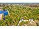 Aerial view of the property, showing the house, garage and the surrounding lot with a lake nearby at 920 E Lake Dr, Tarpon Springs, FL 34688