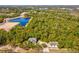 Aerial view of property featuring a home, separate building and surrounded by verdant trees and a large pond at 920 E Lake Dr, Tarpon Springs, FL 34688