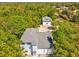 Aerial of light-blue home and two-story garage with a gray roof surrounded by trees at 920 E Lake Dr, Tarpon Springs, FL 34688