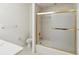 Bright bathroom features a shower/tub combination with glass doors and neutral tile at 920 E Lake Dr, Tarpon Springs, FL 34688