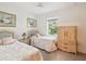 Cozy bedroom with two twin beds, soft floral patterns, and a bright window overlooking a lush landscape at 920 E Lake Dr, Tarpon Springs, FL 34688