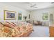 Sunlit bedroom with floral bedding, light carpet, a ceiling fan, and two large windows at 920 E Lake Dr, Tarpon Springs, FL 34688