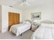 Bright bedroom featuring two twin beds, a ceiling fan, and a closet with shutter doors at 920 E Lake Dr, Tarpon Springs, FL 34688