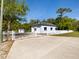 Fenced lot with light-blue home, white trim, shed, and a concrete driveway at 920 E Lake Dr, Tarpon Springs, FL 34688