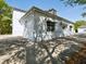 Exterior side view of garage, including awning and multiple windows under tree shadows at 920 E Lake Dr, Tarpon Springs, FL 34688
