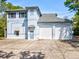 Two story light-blue home featuring a two-car garage and classic architectural accents at 920 E Lake Dr, Tarpon Springs, FL 34688