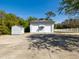 Large two-door garage with small structure on the side, surrounded by a white picket fence at 920 E Lake Dr, Tarpon Springs, FL 34688