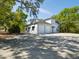 Side-view of a two-story garage with multiple bays and a spiral staircase, and a large concrete parking pad at 920 E Lake Dr, Tarpon Springs, FL 34688