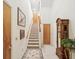 Hallway with staircase, wood doors, decorative rug, grandfather clock and neutral paint at 920 E Lake Dr, Tarpon Springs, FL 34688