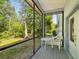 Relaxing screened porch with a table and chair set overlooking a private backyard at 920 E Lake Dr, Tarpon Springs, FL 34688