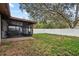 Backyard with a screen enclosed patio area and white fence at 9287 Horizon Dr, Spring Hill, FL 34608