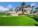 Elegant home with a spacious backyard, lush lawn, and a charming patio area at 940 Monte Cristo Blvd, Tierra Verde, FL 33715