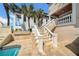 Luxury home with travertine steps and a peek of pool, enhanced by palm trees at 940 Monte Cristo Blvd, Tierra Verde, FL 33715