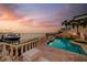 Elegant outdoor living space with a pool, spa, and waterfront views at sunset at 940 Monte Cristo Blvd, Tierra Verde, FL 33715