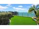 Beautiful backyard with synthetic grass, waterfront views, and dock perfect for entertaining and relaxation at 940 Monte Cristo Blvd, Tierra Verde, FL 33715