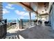 Waterfront balcony with views of the harbor, pool, and boats, featuring a tile floor and columns at 940 Monte Cristo Blvd, Tierra Verde, FL 33715