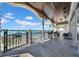 Balcony with tiled floor, view of the pool and the ocean, black metal railing and white pillars at 940 Monte Cristo Blvd, Tierra Verde, FL 33715