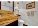 Well-lit half-bathroom with marble sink, modern fixtures, and decorative artwork at 940 Monte Cristo Blvd, Tierra Verde, FL 33715