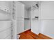 Walk-in closet with custom organizers and wood floor at 940 Monte Cristo Blvd, Tierra Verde, FL 33715