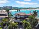 Beautiful waterfront home featuring a tile roof, balcony, mature landscaping, and beachfront access to white sand and turquoise waters at 940 Monte Cristo Blvd, Tierra Verde, FL 33715