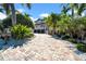 Charming home with a circular driveway and lush tropical landscaping at 940 Monte Cristo Blvd, Tierra Verde, FL 33715