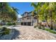 Stately home with lush landscaping, a multi-car garage, and a paver driveway at 940 Monte Cristo Blvd, Tierra Verde, FL 33715