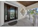Elegant front door with dark wood and intricate glass design, complemented by decorative wall art at 940 Monte Cristo Blvd, Tierra Verde, FL 33715