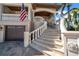 Elegant home entrance featuring stone steps, a charming balcony, and a multi-car garage at 940 Monte Cristo Blvd, Tierra Verde, FL 33715