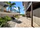 Landscaped side yard featuring a paver pathway and lush tropical greenery at 940 Monte Cristo Blvd, Tierra Verde, FL 33715