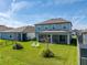 Spacious backyard with a covered patio, green lawn, and white Adirondack chairs perfect for relaxation at 11232 Bram Bay Ct, San Antonio, FL 33576