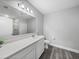 Bright bathroom with long counter and sink, toilet, shower and wood look floors at 11232 Bram Bay Ct, San Antonio, FL 33576