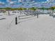 Beach volleyball court with crystal-clear turquoise water and lounge chairs, promising fun-filled days at 11232 Bram Bay Ct, San Antonio, FL 33576