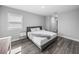 Bedroom with wood look floors, side tables, and modern gray upholstered bedframe at 11232 Bram Bay Ct, San Antonio, FL 33576