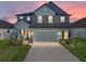 Charming two-story home featuring a gray exterior, landscaped yard, and a spacious two-car garage at sunset at 11232 Bram Bay Ct, San Antonio, FL 33576