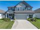Charming two-story home featuring a gray exterior, landscaped yard, and a spacious two-car garage at 11232 Bram Bay Ct, San Antonio, FL 33576