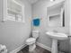 Stylish half bathroom with a pedestal sink, modern fixtures, and a window for natural light at 11232 Bram Bay Ct, San Antonio, FL 33576