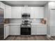 Modern kitchen boasts stainless steel appliances, sleek white cabinetry, and stylish subway tile backsplash at 11232 Bram Bay Ct, San Antonio, FL 33576