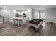 Open-concept living space with modern kitchen, a spacious island, and billiard table for recreation at 11232 Bram Bay Ct, San Antonio, FL 33576