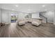 Expansive living room featuring hardwood floors, sectional sofa, sliding glass doors, and a staircase at 11232 Bram Bay Ct, San Antonio, FL 33576